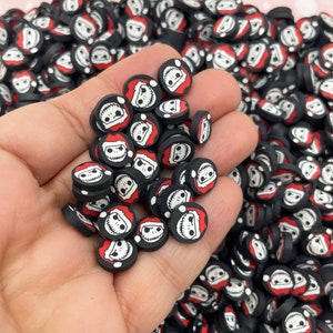 May include: A large pile of black and red round polymer clay charms with a white Jack Skellington face wearing a Santa hat.