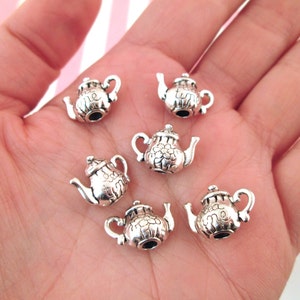 May include: Six silver teapot charms with the words "Tea Time" engraved on them. The charms are perfect for adding a touch of whimsy to jewelry or crafts.