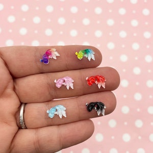 Puede incluir: Seis abalorios de pez dorado de resina en varios colores, incluyendo arcoíris, rosa, rojo, azul y negro. Los abalorios son pequeños y tienen un acabado brillante.