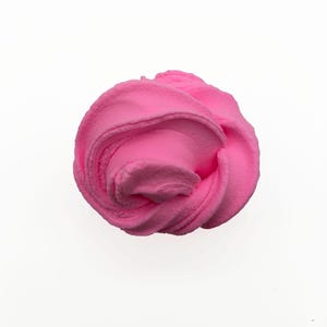 May include: A close-up shot of a vibrant pink, fluffy slime. The slime is swirled into a rounded shape, with visible textures and folds. The background is plain white, highlighting the bright color and soft appearance of the slime.