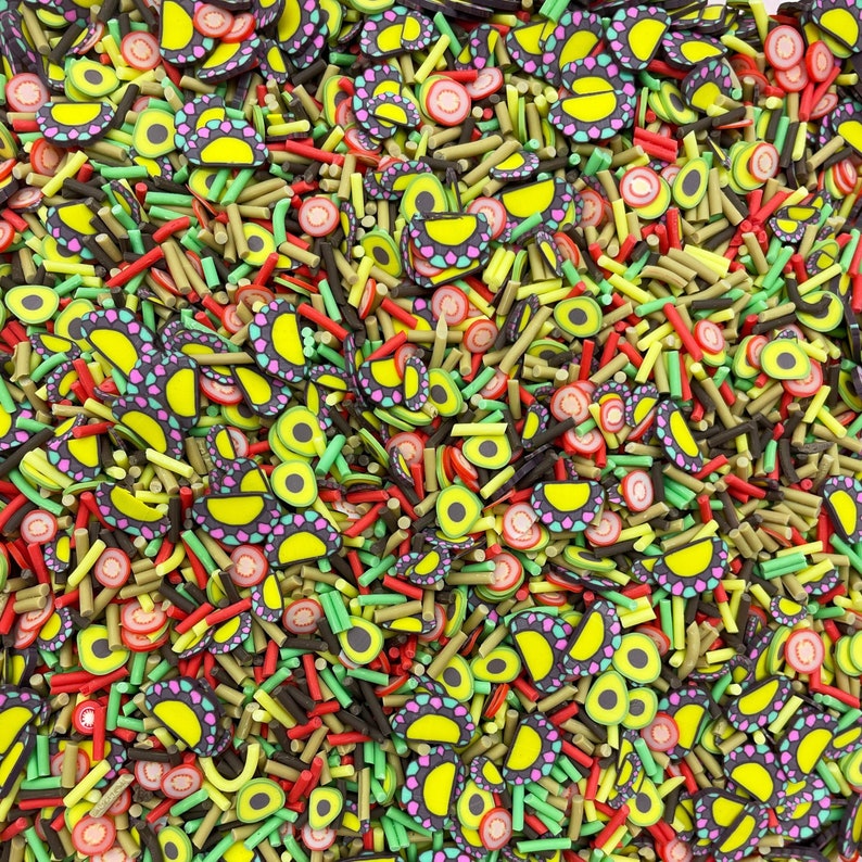 May include: A colorful mix of sprinkles and candy shapes, including avocado halves, lime slices, and red and green candy sticks.