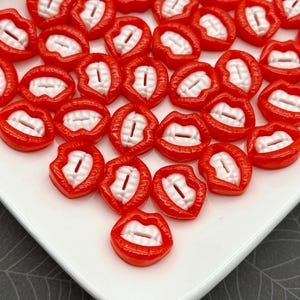 Peut inclure: Plusieurs fausses dents de vampire en plastique rouge, en forme de bouches ouvertes avec des dents blanches. Les fausses dents sont brillantes et détaillées, parfaites pour Halloween ou les projets de costumes.