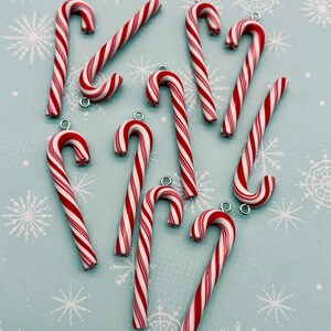 a collection of red and white striped candy canes arranged on a light blue background with white snowflakes.