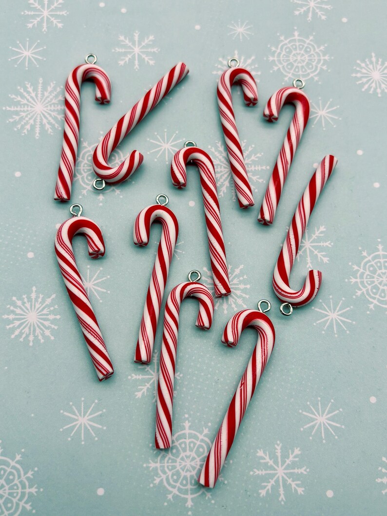 a collection of red and white striped candy canes arranged on a light blue background with white snowflakes.