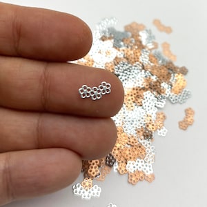 a person's hand holding a tiny diamond ring