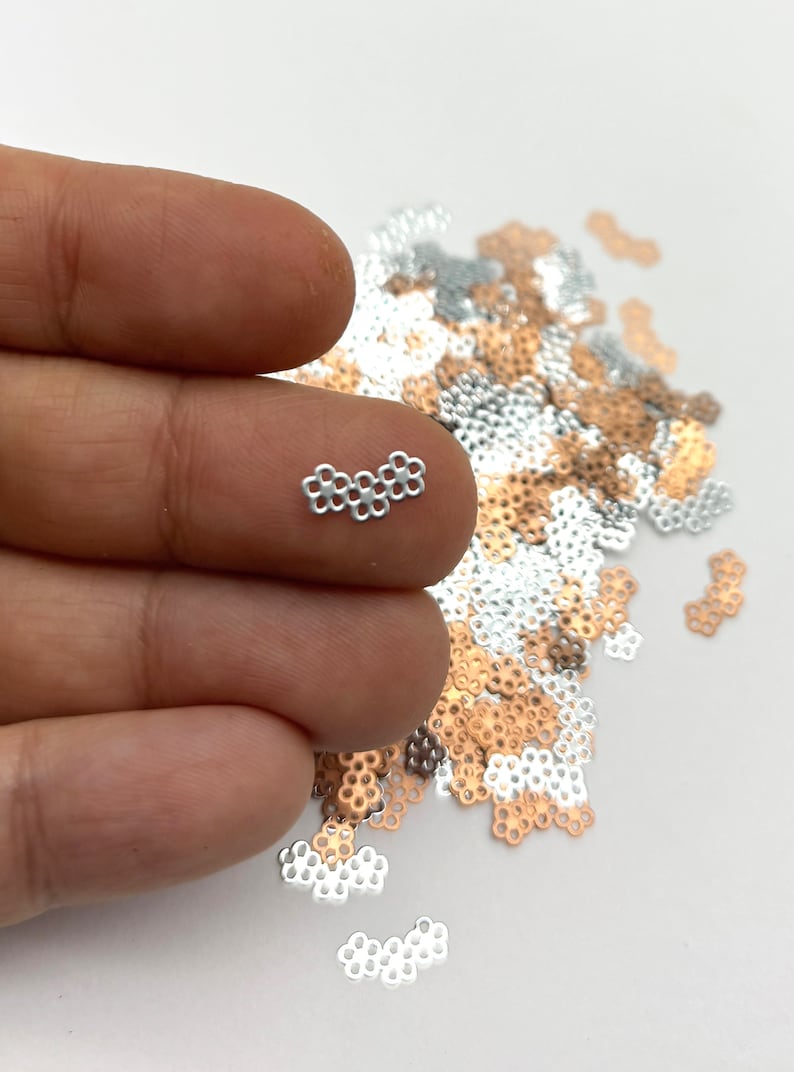 a person's hand holding a tiny diamond ring