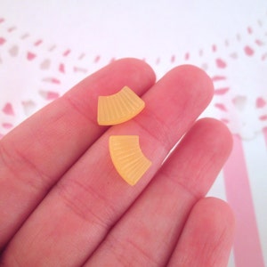 May include: Two small, yellow, fan-shaped plastic earrings.