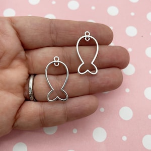Può includere: Due ciondoli a forma di pesce in metallo argentato con un anello in cima per appenderli. I ciondoli hanno la forma di un pesce con una coda a forma di cuore.