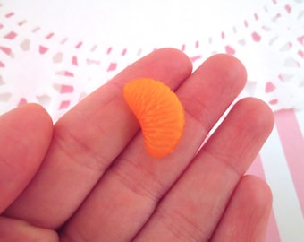 May include: A single orange slice made of plastic, perfect for dollhouse or miniature food projects.