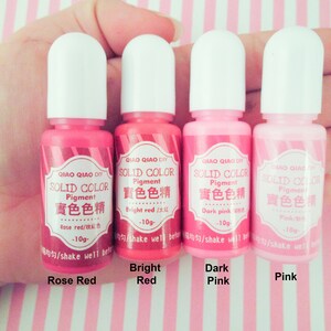 Pu&ograve; includere: Quattro piccoli flaconi di pigmento rosa, rosso e rosso rosato. Ogni flacone &egrave; etichettato "QIAO QIAO DIY SOLID COLOR Pigment" e include il nome del colore in inglese e cinese. I flaconi sono etichettati "Rose Red", "Bright Red", "Dark Pink" e "Pink".