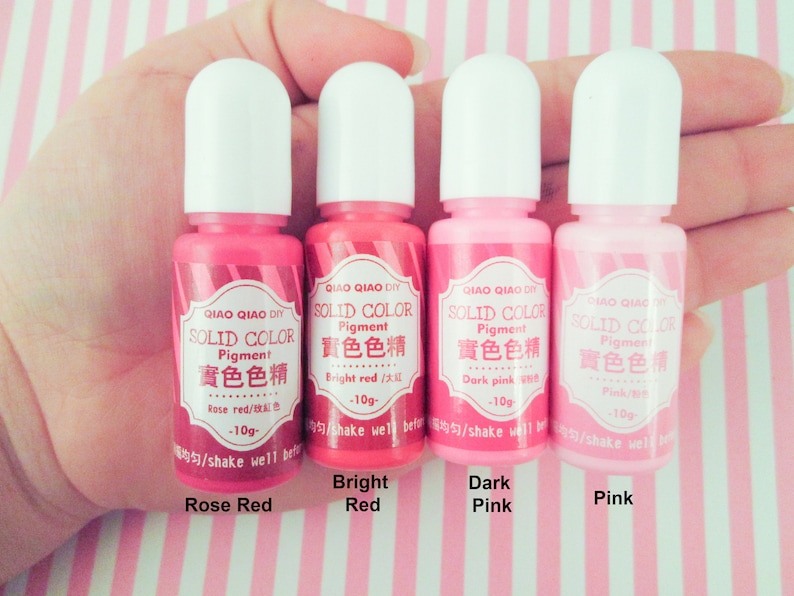 Pu&ograve; includere: Quattro piccoli flaconi di pigmento rosa, rosso e rosso rosato. Ogni flacone &egrave; etichettato "QIAO QIAO DIY SOLID COLOR Pigment" e include il nome del colore in inglese e cinese. I flaconi sono etichettati "Rose Red", "Bright Red", "Dark Pink" e "Pink".