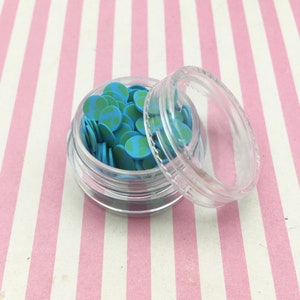 May include: A clear plastic container filled with small blue and green earth-shaped sprinkles. The container has a clear lid.