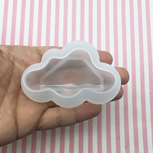 Puede incluir: Un molde de silicona transparente con forma de nube con una abertura hexagonal en el centro.