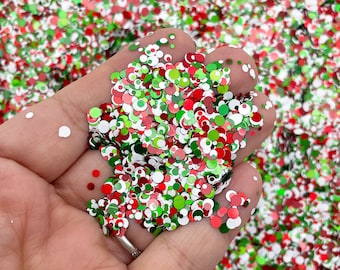 May include: A handful of red, green, and white glitter confetti. The confetti is in the shape of small circles.