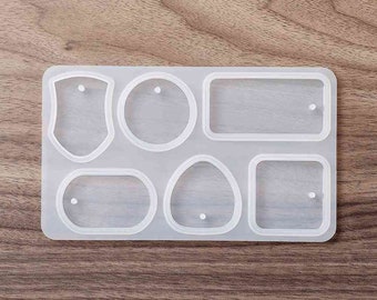 May include: A clear silicone mold with six different shapes for making jewelry or other crafts. The shapes include a shield, a circle, a rectangle, an oval, and two squares.