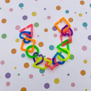 A colorful arrangement of various shapes and objects, including a heart-shaped piece, a triangle, and a star, against a background of multicolored polka dots.