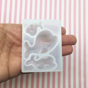 May include: A clear silicone mold with three dolphin shapes. The mold is designed for making resin crafts.