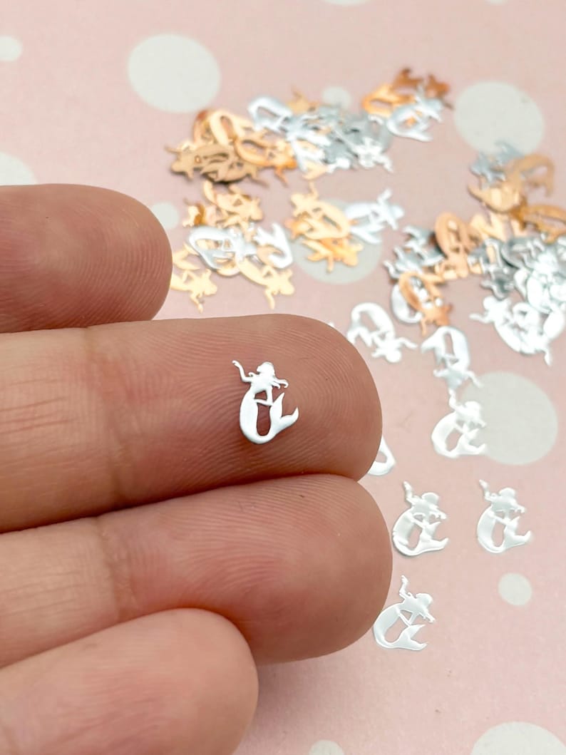 a person is holding a tiny silver ring