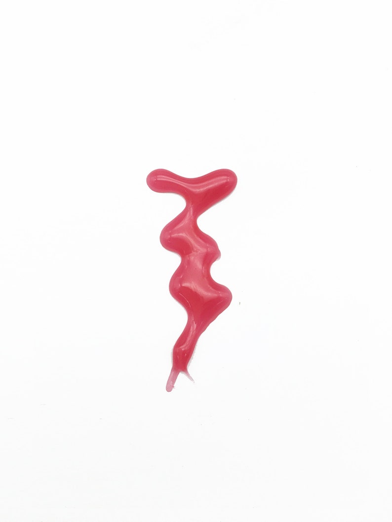 May include: A pink, gooey substance drips down a white surface, forming a unique shape.