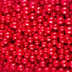 Puede incluir: Una imagen de primer plano de una gran cantidad de cuentas redondas rojas brillantes. Las cuentas están estrechamente empaquetadas, creando una superficie uniforme y texturizada.