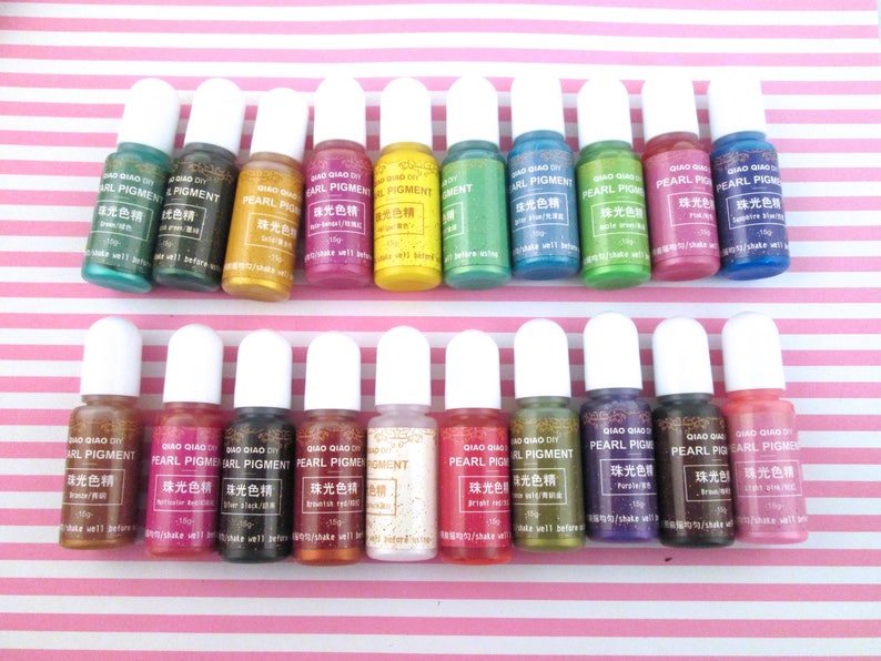 May include: Twenty bottles of pearlescent pigment in various colors, including green, blue, red, gold, and purple. Each bottle is labeled with the text "Pearl Pigment" in Chinese and English.
