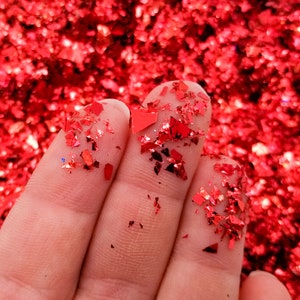 May include: Red iridescent glitter flakes, perfect for crafting and adding sparkle to projects.