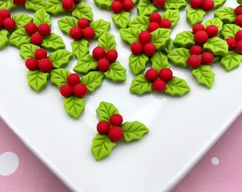 Könnte beinhalten: Ein weißer Teller mit grünen Stechpalmenblättern und roten Beeren. Die Stechpalmenblätter sind aus Fondant und eignen sich perfekt zum Dekorieren von Kuchen und Cupcakes.