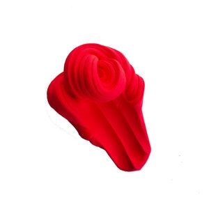 May include: A vibrant, abstract sculpture in a bright red hue. The form is composed of swirling, layered shapes, creating a dynamic and textured appearance. The artwork is set against a clean white background.