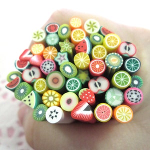 May include: A collection of colorful polymer clay fruit slices, including watermelon, kiwi, lemon, lime, strawberry, and orange, arranged in a circle.