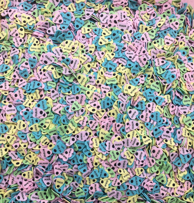 May include: A large pile of colorful heart-shaped foam stickers with black dots and the word "OUIJA" printed on them.