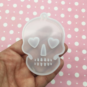 May include: Clear silicone mold shaped like a skull with heart-shaped eyes. The mold is designed for making resin crafts.