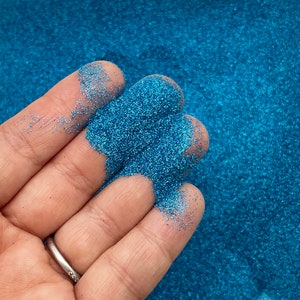 Può includere: Primo piano di glitter blu turchese, un materiale popolare per l'artigianato e la decorazione.