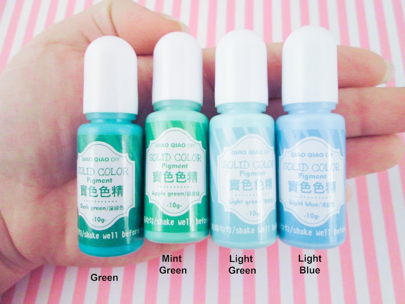 Pu&ograve; includere: Quattro piccoli flaconi di pigmento liquido nei colori verde scuro, verde menta, verde chiaro e blu chiaro. Ogni flacone ha un tappo bianco e un'etichetta che recita "Pigmento colore solido" in inglese e cinese. Le etichette elencano anche il colore del pigmento e la quantit&agrave; in grammi.