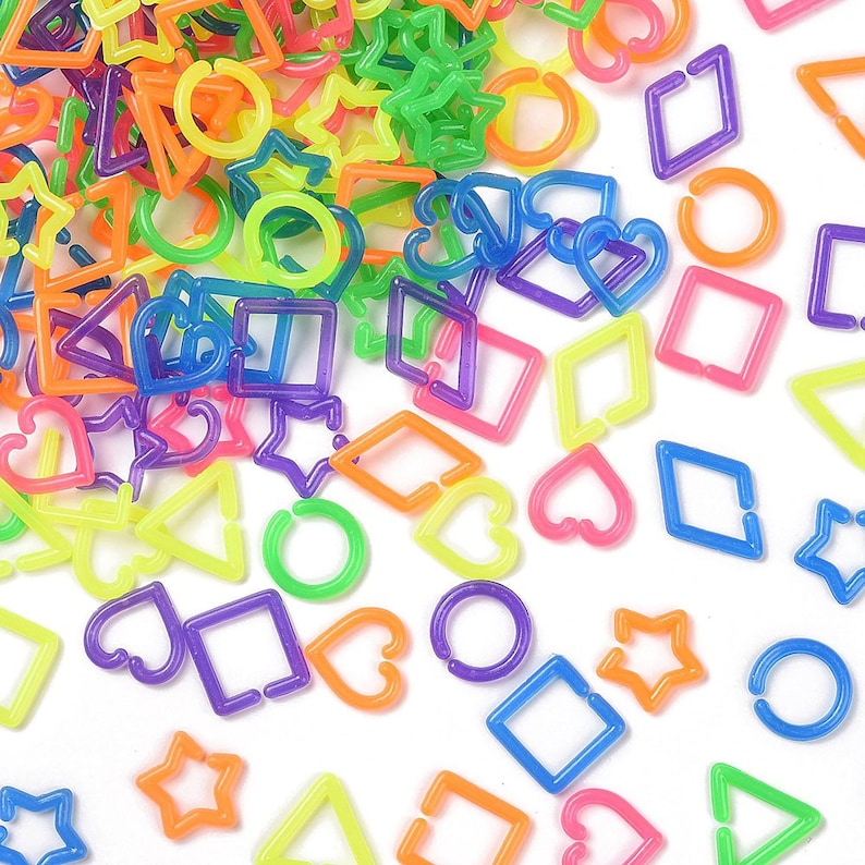 a variety of colorful plastic shapes, including stars, hearts, and other geometric designs, scattered across a white background.