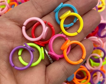 May include: Assortment of colorful plastic rings with a flat top. The rings are in various colors, including purple, green, yellow, orange, red, pink, and blue.