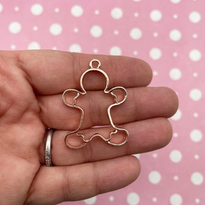 May include: A gold-toned metal gingerbread man charm with a loop at the top for hanging.