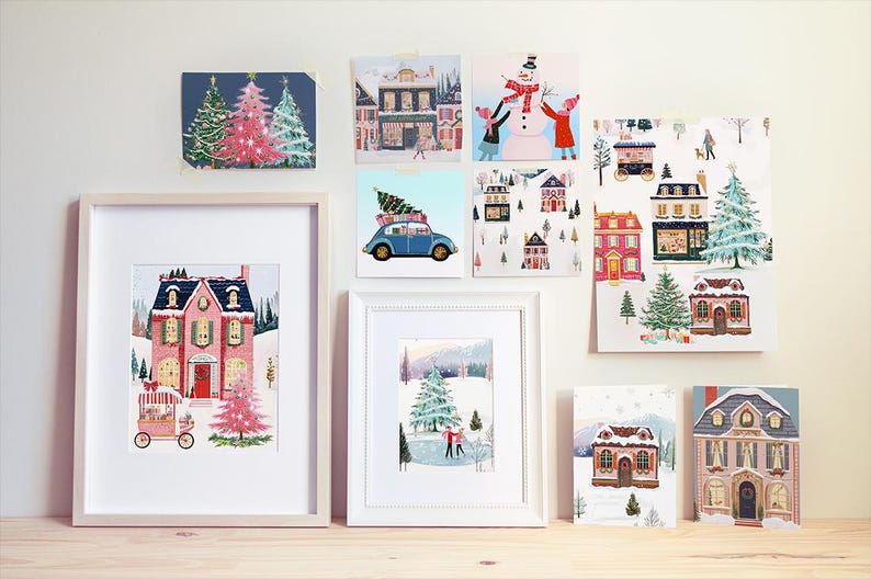 May include: A collection of eight framed illustrations featuring winter scenes with houses, trees, and snow. The illustrations are in a variety of styles, including cartoon, realistic, and abstract.