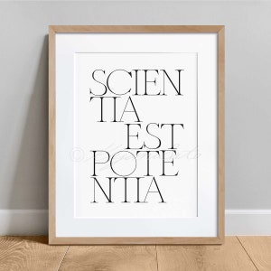 May include: A framed print with the text "SCIENTIA EST POTENTIA" in black lettering on a white background.