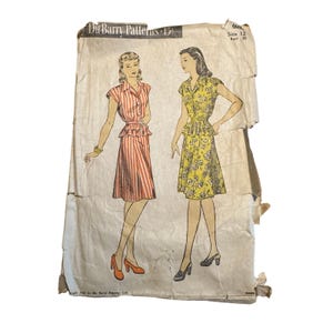 May include: A vintage Du Barry Patterns sewing envelope, size 12, bust 30, featuring illustrations of two dresses. One dress has red and white vertical stripes, while the other has a yellow floral print. The paper envelope is worn and creased.