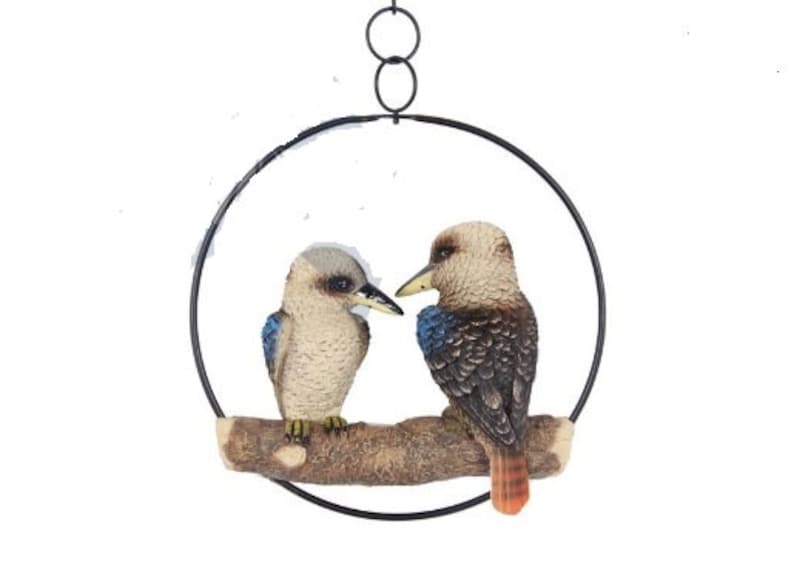 May include: A hanging metal circle with two brown and white birds perched on a branch. The birds have blue accents on their wings and one has an orange tail.