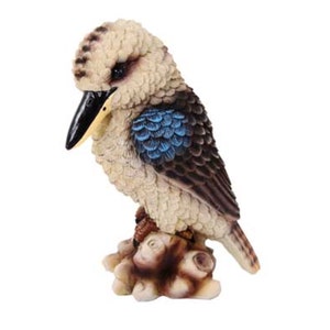 May include: A small, detailed figurine of a kookaburra bird perched on a tree branch. The bird is brown and white with blue feathers on its wings. The figurine is made of resin and is a great addition to any home decor.
