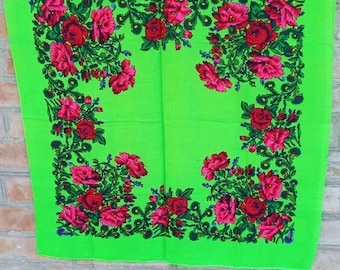 May include: A square scarf in a vibrant lime green color featuring a prominent floral pattern. The design consists of clusters of deep pink and red roses with dark green leaves and stems arranged in a decorative border around the center.
