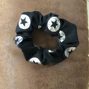 May include: Black scrunchie with silver star-shaped designs.