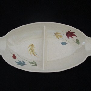 May include: A divided serving dish with a cream-colored background and a leaf design in shades of red, yellow, green, and blue.