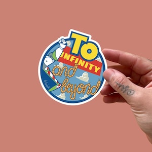 Könnte beinhalten: Ein runder Aufkleber mit Buzz Lightyear und dem Schriftzug "To Infinity and Beyond". Das Design umfasst einen blauen Hintergrund mit Wolken und gelbem und rotem Text. Der Aufkleber wird von einer Hand gehalten.