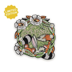 Peut inclure: Écusson brodé avec un design fantaisiste d'un raton laveur, d'un renard et d'un lapin dans une couronne florale. L'écusson porte l'inscription "Lost Girl" en écriture cursive. Un autocollant jaune "Limited Edition" est dans le coin supérieur gauche.