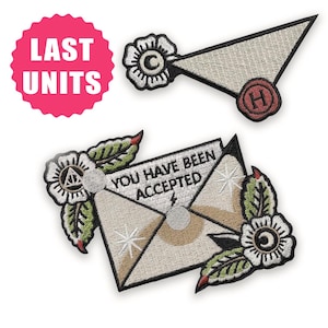 May include: A white ceramic mug with a black handle and the text "But First, Coffee" in a bold, black font. The mug is set against a blurred background, suggesting a cosy setting.