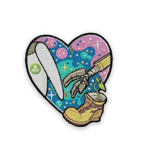 May include: Embroidered heart-shaped patch with a robot arm reaching towards a plant growing from a boot. The patch features a white wing, a green logo, and a colorful background with stars and dots. The patch is outlined in black.