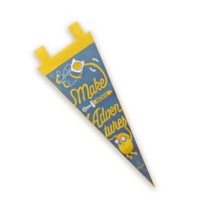 May include: Blue pennant flag with yellow accents and the text "Make More Adventures." Features cartoon characters Finn and Jake from Adventure Time. The pennant is made of felt and has a triangular shape.
