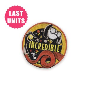 May include: Embroidered patch featuring a circular design with the word "INCREDIBLE" in yellow, a character illustration, and a red swirl. The patch has a yellow border and a pink "LAST UNITS" sticker.